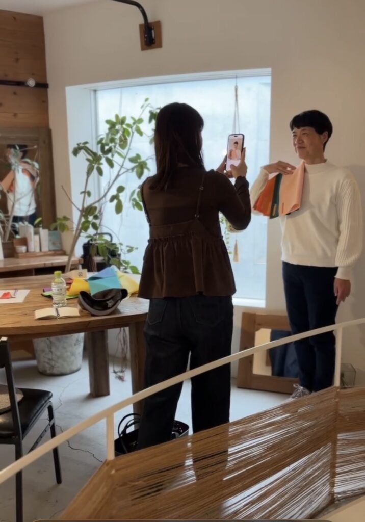 パーソナルカラー診断後、お客様のベストカラーのドレープをあてて撮影している様子。自然光の入るサロンで、似合う色に包まれたお客様の表情がやわらぎ、魅力が引き出されているひととき。