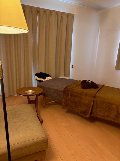 横浜・鶴見の自宅サロン iroka の施術ルーム。 落ち着いた照明の中でエステベッドが設置された 静かなプライベート空間の写真。 リピーター様限定の自宅エステサロンです。